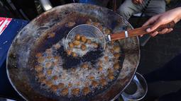 Pedagang Palestina menyiapkan falafel di pasar menjelang buka puasa selama bulan suci Ramadhan di kota Rafah, Jalur Gaza selatan, pada 10 April 2022. (SAID KHATIB / AFP)