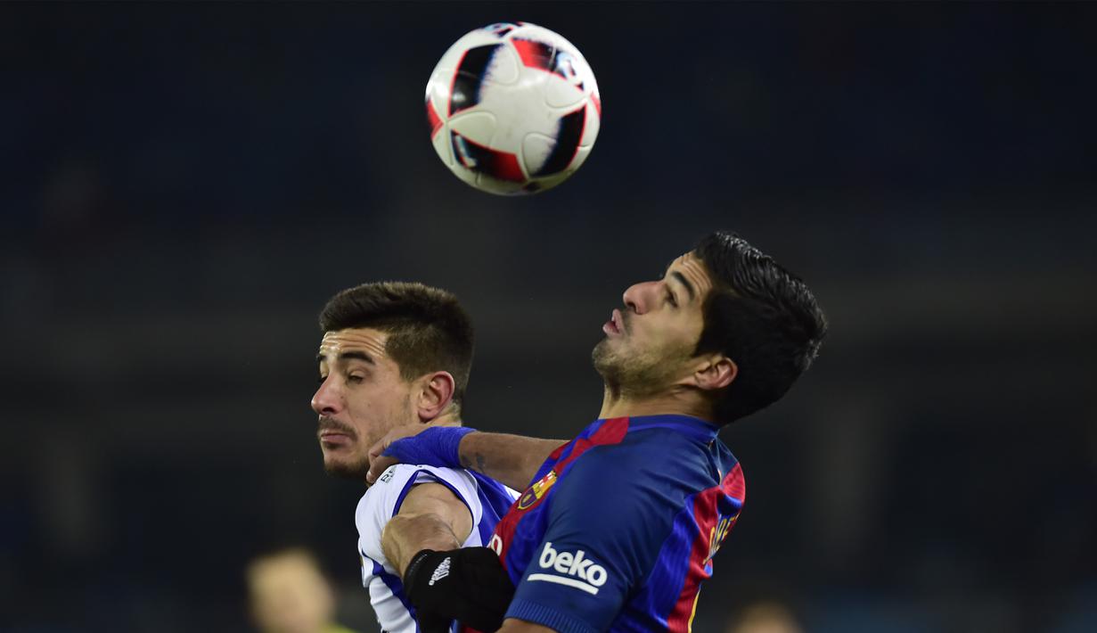 Aksi Luis Suarez (kanan) berebut bola dengan pemain Real Sociedad, Yuri Berbiche dpada laga prempat final Copa Del Rey di Anoeta stadium, San Sebastian,  Kamis (19/1/2017). Barcelona menang tipis 1-0.  (AP/Alvaro Barrientos)