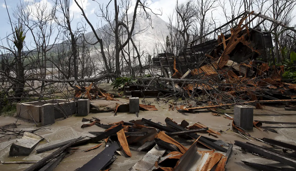 Sebuah rumah hancur akibat erupsi Gunung Sinabung, di Beras Tepu Desa, Karo, Sumatera Utara, 21 Juni 2015. Ribuan warga yang tinggal di sekitar lereng Gunung Sinabung telah meninggalkan rumah mereka dan pindah ke kamp-kamp pengungsi. (REUTERS/Beawiharta)