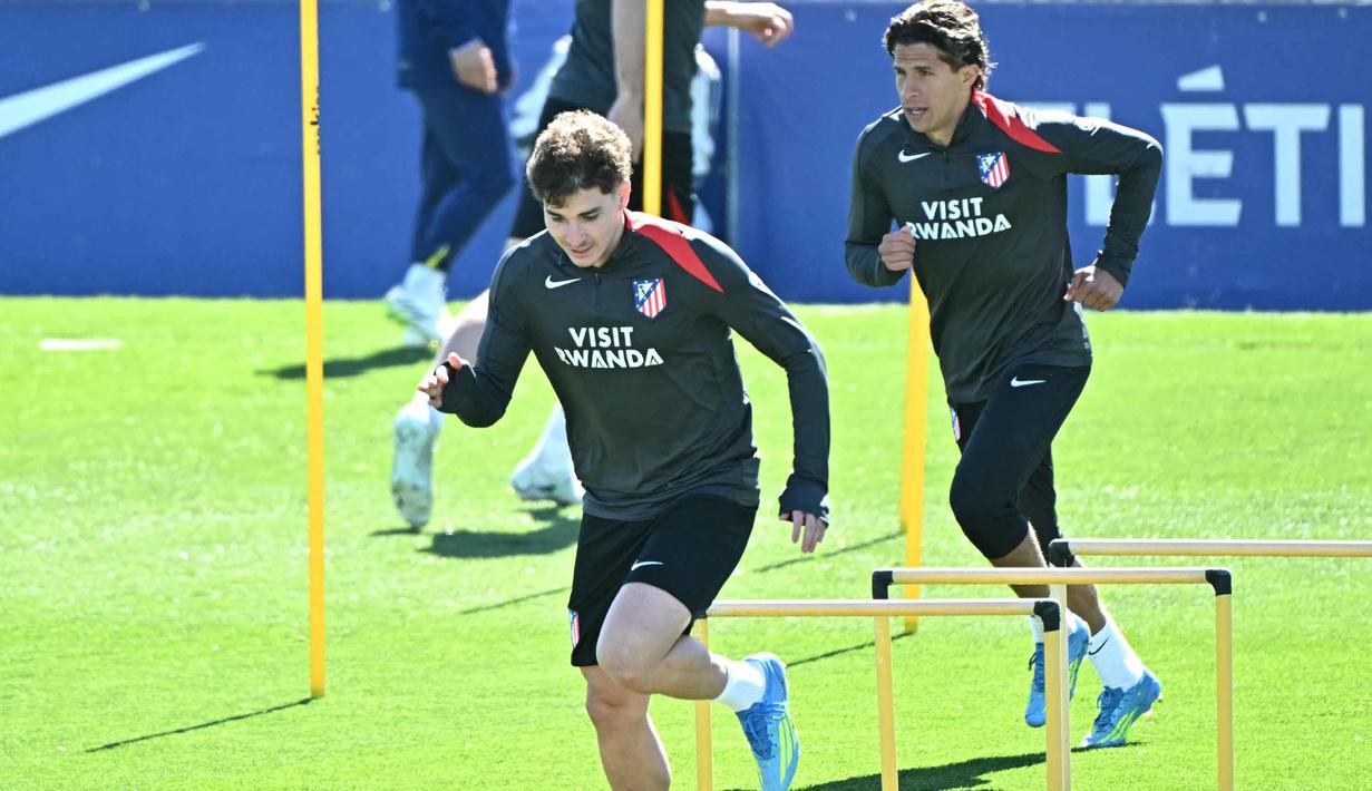 Sebagai informasi, dalam dua pertemuan sebelumnya di fase gugur Liga Champions, Los Rojiblancos berhasil menyingkirkan Barcelona, yakni pada musim 2013/2014 dan 2015/2016. Tampak dalam foto, penyerang Atletico Madrid asal Argentina, Julian Alvarez (kiri) dan Giuliano Simeone, menghadiri sesi latihan menjelang pertandingan kedua perempat final Liga Champions 2025/26 melawan Barcelona di tempat latihan klub di Majadahonda, pinggiran kota Madrid, pada Senin 13 April 2026. (Javier SORIANO/AFP)