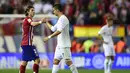 Pemain Atletico Madrid, Filipe Luis (kiri) bersalaman dengan Cristiano Ronaldo usai Derby laga La Liga Spanyol yang berakhir imbang di Stadion Vicente Calderon,  Madrid, (4/10/2015). (AFP Photo/ Javier Soriano)