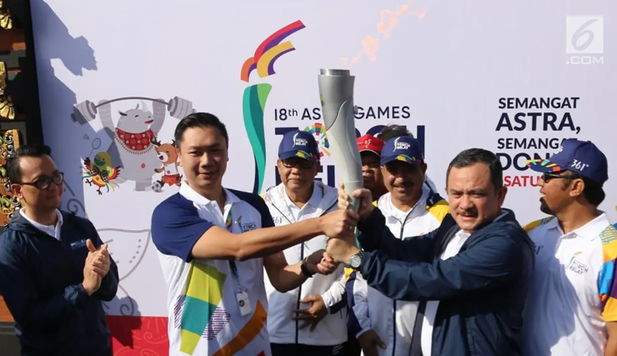 Ketua Koordinator Wilayah Grup Astra Bali Haris Prasetya dan Head of Environment & Social Responsibility PT Astra International Tbk Riza Deliansyah memegang api obor Asian Games 2018 di Banjar Berseri Astra Denpasar, Bali (24/7). (Liputan6.com/Pool/Ilham)