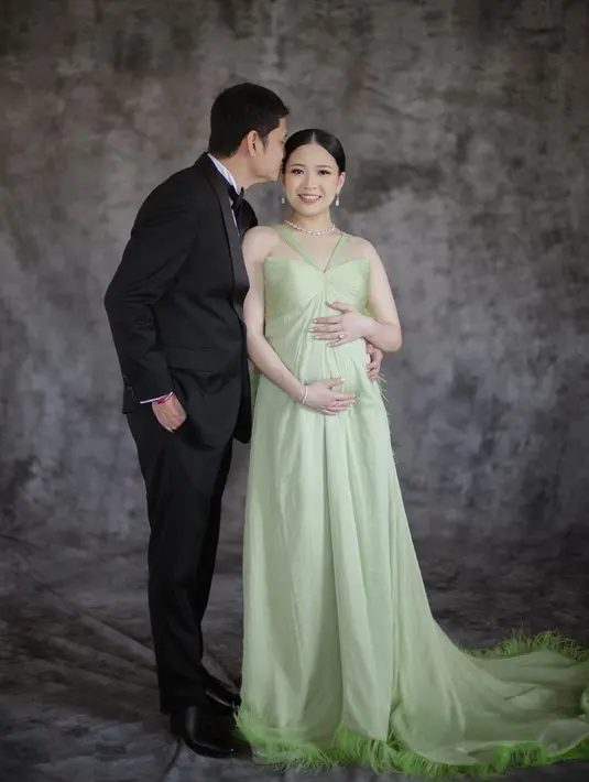 Maternity shoot dijalani Jessica Tanoesoedibjo di Bali. Bersama sang suami, Jessica tampil elegan dengan gaun hijau, detail halter neck yang flowy menjuntai ke lantai. [Foto: Instagram/jessicatanoe]