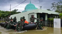 Prajurit TNI dengan perahut karet memberikan bantuan untuk warga terdampak banjir setelah tiga hari hujan lebat di Banda Aceh, Aceh, Sabtu (9/5/2020). Banjir akibat intensitas hujan tinggi mengakibatkan sebagian besar kawasan di ibu kota Provinsi Aceh digenangi air. (Photo by CHAIDEER MAHYUDDIN/AFP)