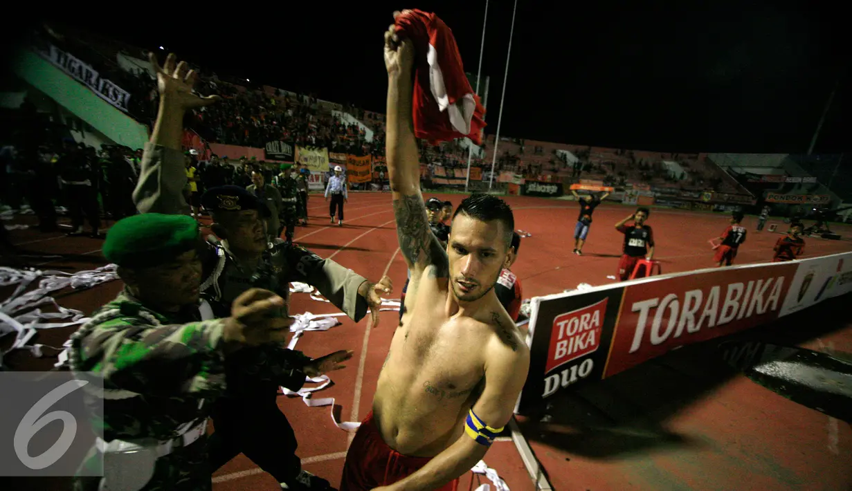 Penyerang Persija, Rafael Maitimo di hadang petugas saat akan memberikan kostumnya kepada Jakmania usai pertandingan 8 besar piala Jendral Sudirman di Stadion manahan Solo (15/12). Persija menang atas PS TNI dengan skor 1-0. (Liputan6.com/Boy Harjanto)
