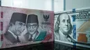 Uang kertas Rp 100.000 dipajang berdampingan dengan uang dolar Amerika Serikat di salah satu kantor penukaran, Jakarta, Kamis pada 4 Juni 2026. (Yasuyoshi Chiba/AFP)