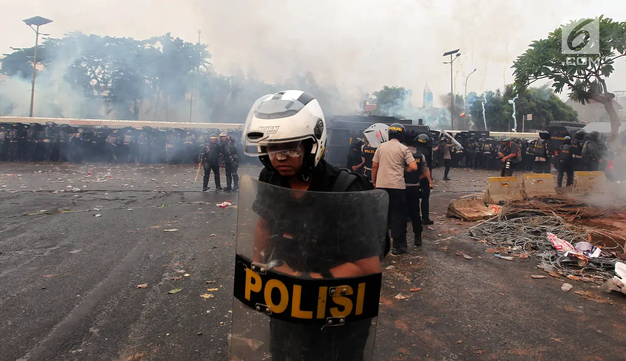 Polisi menghalau mahasiswa dalam demonstrasi menolak pengesahan RUU KUHP dan revisi UU KPK di depan Gedung DPR, Jakarta, Selasa (24/9/2019). Mahasiswa lari tunggang langgang setelah aparat kepolisian menembakkan gas air mata dan water cannon. (Liputan6.com/JohanTallo)
