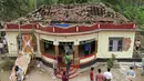 Warga berkumpul di sebuah kuil yang rusak akibat kebakaran di Kollam, India Selatan, Minggu (10/4). Media setempat melaporkan, kebakaran terjadi setelah perayaan yang menyalakan kembang api untuk menandai akhir sebuah festival. (REUTERS/Sivaram V)