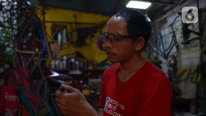 Pemilik workshop Alam Project, Alam bersiap menyelesaikan pembuatan sepeda multiguna atau kargo di bengkelnya kawasan Tangerang Selatan, Sabtu (10/7/2020). Harga sepeda kargo dipatok Rp3-8 juta tergantung jenis dan ukuran sepeda. (merdeka.com/Imam Buhori)