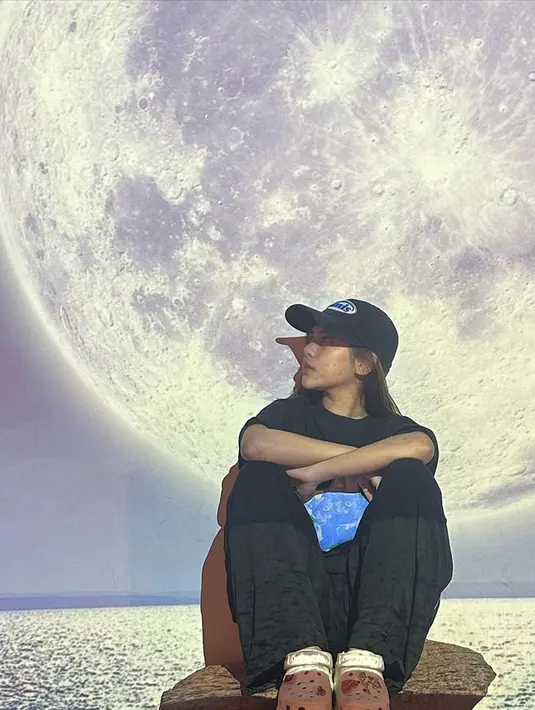Tampil kasul serba hitam dengan topi, Ziva berpose candid di sebuah kafe unik yang berada di Chiangmai. Di sana, banyak spot foto yang unik dengan tema planet. Pelantun lagu 'Peri Cintaku' itu pun tak bisa melewatkan momen tersebut, dan segera bergaya untuk mengabadikannya dalam sebuah foto. (Liputan6.com/IG/@zivamagnolya)