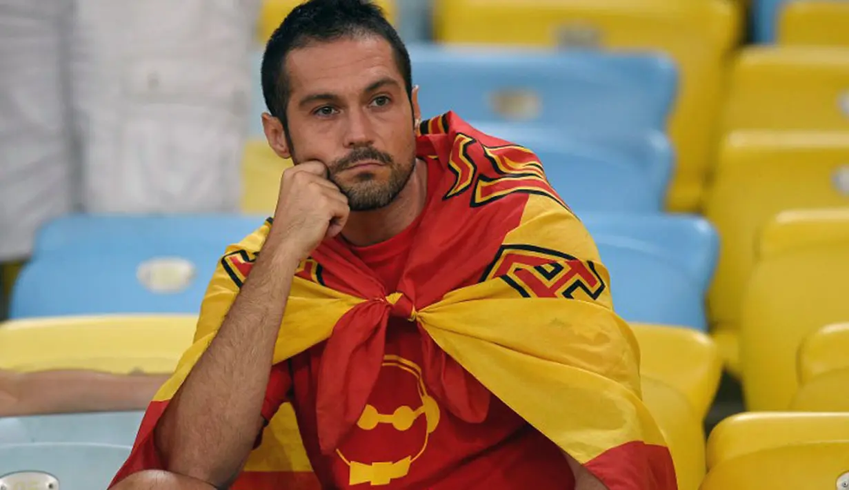 Raut wajah kesedihan suporter Spanyol, usai menyaksikan kekalahan La Furia Roja 0-2 atas Chile di babak penyisihan Piala Dunia Grup B di Stadion Maracana, Rio de Janeiro, Brasil, (19/6/2014). (AFP PHOTO/Lluis Gene)