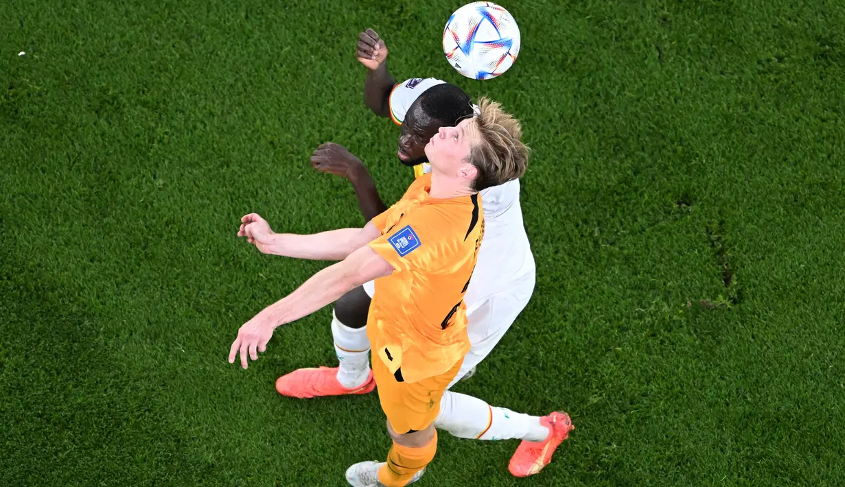Gelandang Senegal #08 Cheikhou Kouyate (atas) berebut bola dengan gelandang Belanda #21 Frenkie De Jong selama pertandingan pada pertandingan kedua Grup A Piala Dunia 2022 di Stadion Al-Thumama di Doha, Senin (21/11/2022). Cheikhou Kouyate tak bisa melanjutkan laga Timnas Senegal vs Timnas Belanda hingga rampung. (Kirill KUDRYAVTSEV / AFP)