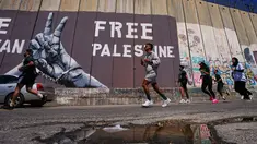Para pelari melewati tembok pemisah Israel saat mereka berkompetisi dalam Maraton Palestina di kota Betlehem, Tepi Barat, Jumat 8 Mei 2026. Maraton Internasional Palestina kembali dilaksanakan pada Jumat 8 Mei 2026, di kota Betlehem, Tepi Barat. (AP Photo/Mahmoud Illean)