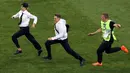 Dua penyusup menerobos memasuki lapangan pada pertandingan sepak bola final Piala Dunia 2018, Prancis melawan Kroasia di Stadion Luzhniki, Moskow (15/7). Penyusup diketahui merupakan grup band punk Rusia, Pussy Riot.  (AP Photo / Thanassis Stavrakis)