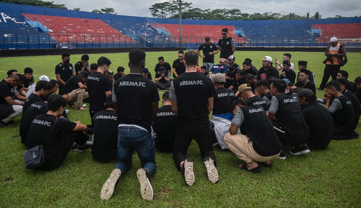 Pemain dan ofisial tim terlihat berkumpul ditengah lapangan dan membacakan doa. (AFP/Juni Kriswanto)