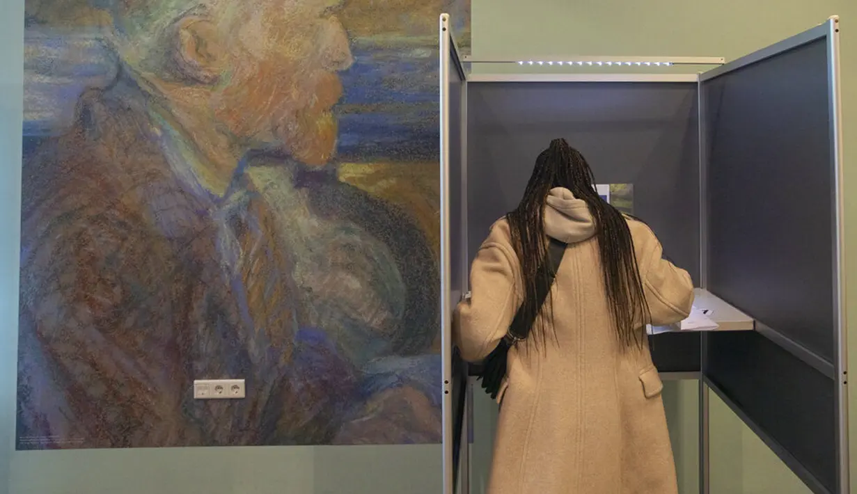 Seorang wanita memberikan suara dalam pemilihan umum di Museum Van Gogh, Amsterdam, Belanda, Rabu (17/3/2021). Pemilu digelar selama tiga hari untuk memungkinkan warga memilih dengan aman selama pandemi virus corona COVID-19. (AP Photo/Peter Dejong)