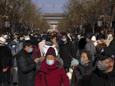 Pengunjung mengunjungi jalan perbelanjaan pejalan kaki di Qianmen pada hari pertama liburan Tahun Baru Imlek di Beijing, Minggu (22/1/2023). Orang-orang di seluruh China merayakan Tahun Baru Imlek pada hari Minggu dengan pertemuan keluarga besar dan kerumunan orang mengunjungi kuil-kuil setelah pemerintah mencabut kebijakan "nol-COVID" yang ketat, menandai perayaan meriah terbesar sejak pandemi dimulai tiga tahun lalu. (AP Photo/Andy Wong)