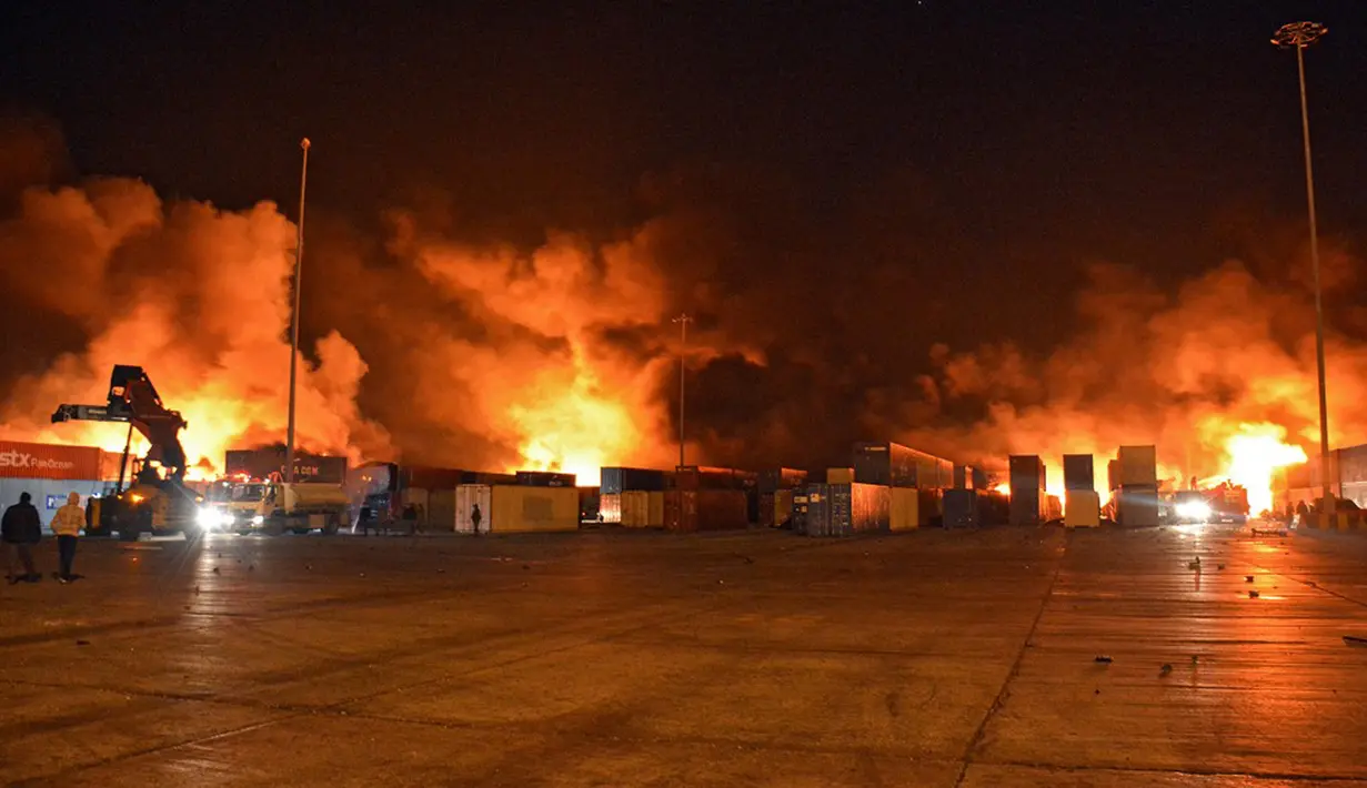 Petugas pemadam kebakaran berjuang melawan kobaran api setelah serangan udara Israel di Pelabuhan Latakia, Suriah, 28 Desember 2021. Serangan udara Israel menghantam Pelabuhan Latakia sekitar pukul 03.21 waktu setempat. (SANA/AFP)