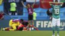 Joshua Kimmich terpaku melihat para pemain Korea Selatan merayakan gol Son Heung-min pada laga grup F Piala Dunia 2018 di Kazan Arena, Kazan, Rusia, (27/6/2018). Kekalahan tersebut membuat Jerman gagal melju ke babak 16 besar. (AP/Thanassis Stavrakis)