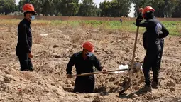 Gambar dari video pada 14 Juli 2019, pekerja Dewan Sipil Raqqa menggali kuburan massal berisi tulang belulang manusia di Raqqa, Suriah, 14 Juli 2019. Sejauh ini para pekerja telah menemukan 313 mayat dari kuburan massal yang ditemukan bulan lalu di dekat kota di Suriah utara tersebut. (AP Photo)
