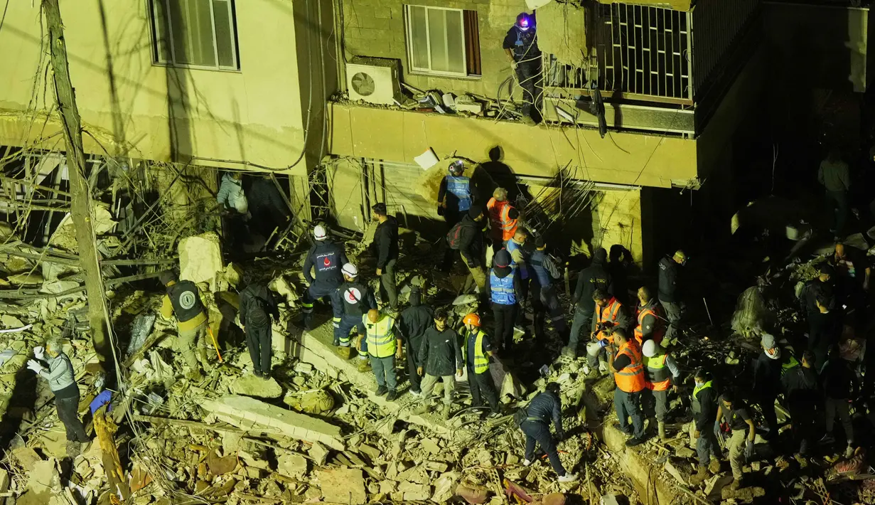 Serangan tersebut menghantam sebuah apartemen di Ghobeiri, lokasi yang disebut-sebut menjadi tempat para pemimpin Radwan menggelar pertemuan. Tampak dalam foto, petugas penyelamat mencari korban selamat di antara reruntuhan bangunan yang rusak setelah serangan udara Israel di Dahiyeh, pinggiran selatan Beirut, Lebanon, Rabu 6 Mei 2026. (AP Photo/Hassan Ammar)