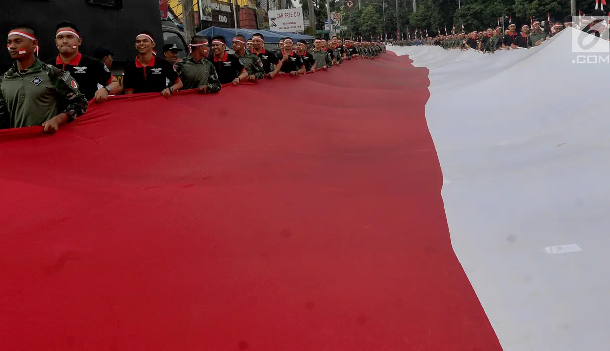 Anggota TNI POLRI  membawa bendera raksasa saat gelaran Festival Merah-Putih (FMP) 2018 di kawasan Air Mancur, Bogor,  Minggu (5/8). Kegiatan tersebut dalam rangka menyambut HUT Kemerdekaan RI ke-73. (Merdeka.com/Arie Basuki)