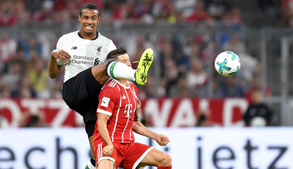 Bek Liverpool, Joel Matip, membuang bola dari striker Bayern Munchen, Robert Lewandowski, pada laga Audi Cup di Stadion Allianz Arena, Munchen, Selasa (1/8/2017). Munchen kalah 0-3 dari Liverpool. (AFP/Christof Stache)