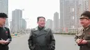 Pemimpin Korea Utara Kim Jong Un (tengah) berbincang dengan para pejabat saat memeriksa lokasi kompleks perumahan 10.000-flat yang sedang dibangun di Pyongyang (16/3/2022). Kim telah menghadiri upacara peletakan batu pertama situs tersebut Maret lalu. (AFP/STR/KCNA Via KNS)