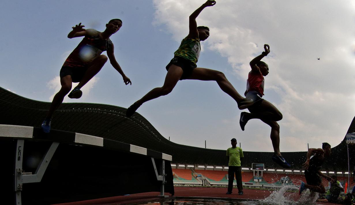 Para pelari melompat saat tampil pada Kejurnas Atletik 2019 nomor 3.000 meter steeplechase senior putra di Stadion Pakansari, Bogor, Rabu (8/8). Kejurnas Atletik berlangsung dari 3-7 Agustus. (Bola.com/Peksi Cahyo)