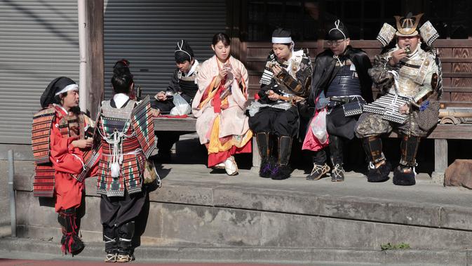 Pemandu Satoshi Kamakura dan peserta mengenakan pakaian tradisional Jepang Samurai saat mengikuti tur situs bersejarah di Kamakura, Jepang (26/11). (AP Photo/Shizuo Kambayashi)