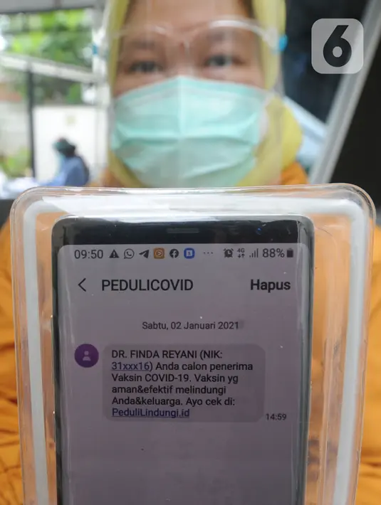Paramedis menunjukkan SMS undangan mengikuti kegiatan vaksin Covid-19 di Puskesmas  Ciganjur, Jakarta Selatan, Kamis (7/1/2021). Direncanakan pelaksanaan vaksin Covid-19 pada 14 Januari besok dengan prioritas bagi para tenaga kesehatan. (merdeka.com/Arie Basuki)