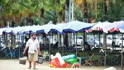 Seorang pedagang membawa makanan untuk dijual di Pantai Pattaya di Provinsi Chonburi, Thailand (15/9/2020). Dengan ditutupnya zona udara dan perbatasan, perekonomian Thailand menderita sejak Maret akibat kurangnya arus kas dari industri pariwisata. (Xinhua/Rachen Sageamsak)