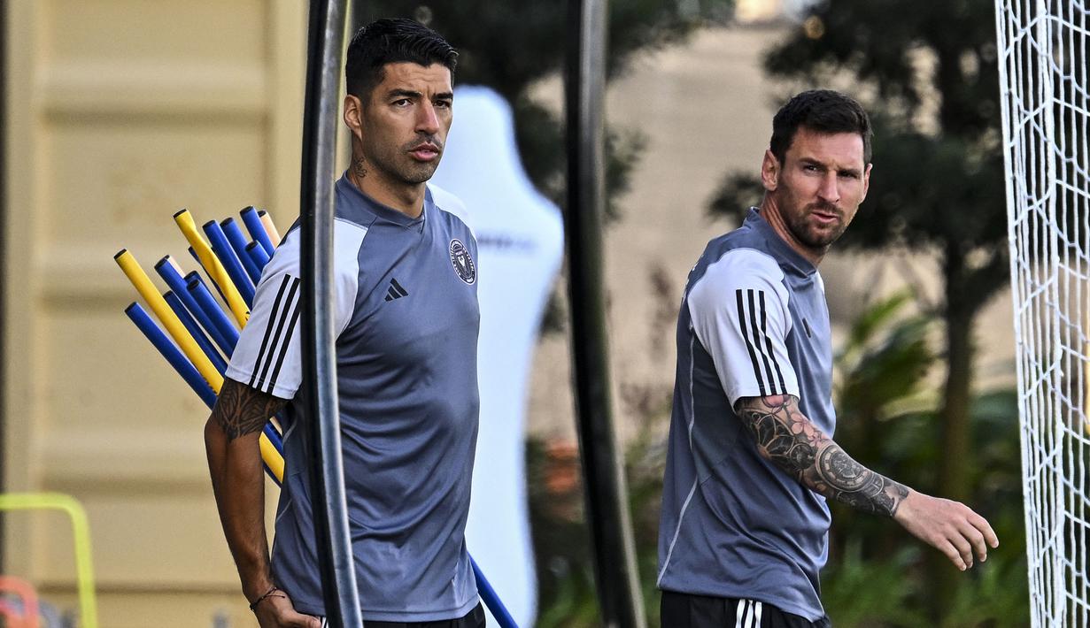 Pemain baru Inter Miami, Luis Suarez (kiri) bersama Lionel Messi mendatangi latihan pramusim Inter Miami di Florida Blue Training Center, dekat DRV PNK Stadium, Florida, Fort Lauderdale, Sabtu (13/01/2024) waktu setempat. (AFP/Chandan Khanna)