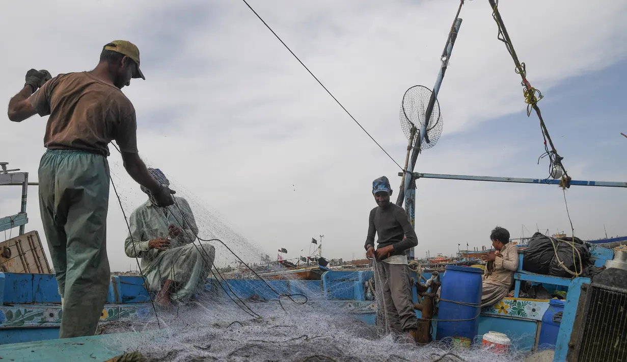 Nelayan Pakistan menyiapkan jaring ikan mereka di atas kapal di pelabuhan di Karachi (3/4). Pembuatan kapal buatan Pakistan menghasilkan ratusan kapal setiap tahun untuk memenuhi permintaan industri perikanan setempat. (AFP Photo/Asif Hassan)