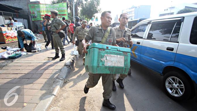Petugas Satpol PP menertibkan Pedagang Kaki Lima (PKL) yang berjualan di kawasan Tanah Abang, Jakarta (6/11). Puluhan PKL kembali ditertibkan petugas karena dianggap berjualan di tepi jalan dan menimbulkan kesan kumuh. (Liputan6.com/Immanuel Antonius)