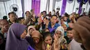 Kegiatan yang berkonsep Garage Day ini bertujuan membantu masyarakat dalam memenuhi kebutuhan atau pangan untuk anak-anak dan keluarga saat merayakan Hari Raya Idul Fitri. Tampak dalam foto, orang-orang mengantre untuk menerima barang-barang gratis seperti pakaian, bahan makanan pokok, dan perlengkapan rumah tangga yang disediakan oleh Asosiasi Organisasi Wanita (GOW) dan pemerintah daerah selama acara aksi sosial tahunan di bulan Ramadan, Surabaya pada Senin 2 Maret 2026. (JUNI KRISWANTO/AFP)