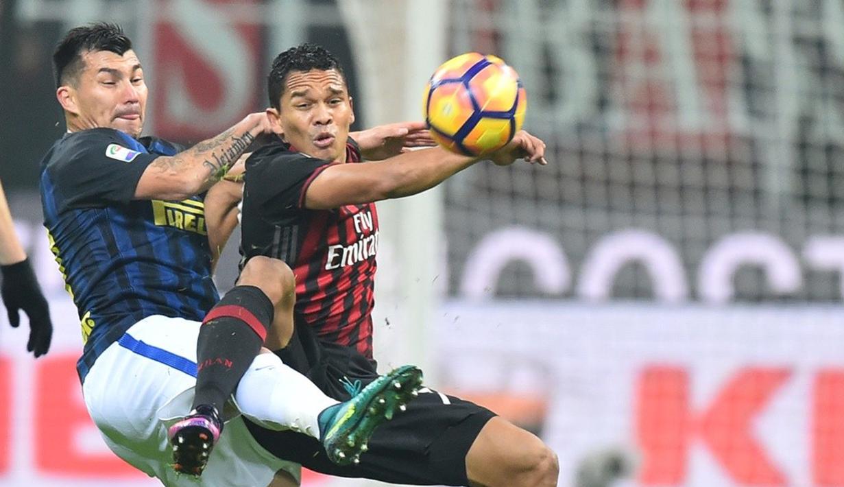 Striker AC Milan, Carlos Bacca (kanan), berduel dengan gelandang Inter Milan, Gary Medel, pada laga pekan ke-13 Serie A di Stadion San Siro, Minggu (20/19/2016). (AFP/Giuseppe Cacace)