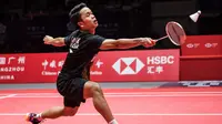 Tunggal putra Indonesia Anthony Sinisuka Ginting memukul kok ke arah Kento Momota dari Jepang pada laga final BWF World Tour Finals 2019 di Tianhe Gymnasium, Guangzhou, China, Minggu (15/12/2019).  Anthony Ginting gagal juara BWF World Tour Finals 2019 setelah takluk 21-17, 17-21, 14-21. (STR/AFP)