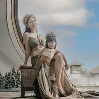 Rachel kompak mengenakan pakaian khas perempuan Bali bersama putrinya, Chava. Chava menggemaskan mengenakan atasan nude dipadu obi dan rok lilit hijaunya. Lengkap dengan aksesori bros dan rambut. (@rachelvennya)