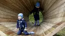 Sejumlah anak bermain di megafon raksasa dari kayu buatan sekelompok mahasiswa arsitektur interior di dalam hutan Estonia, 28 September 2015. Megafon ini dibuat untuk mendengarkan suara hutan dan mahluk yang tinggal di dalamnya. (REUTERS/Ints Kalnins)