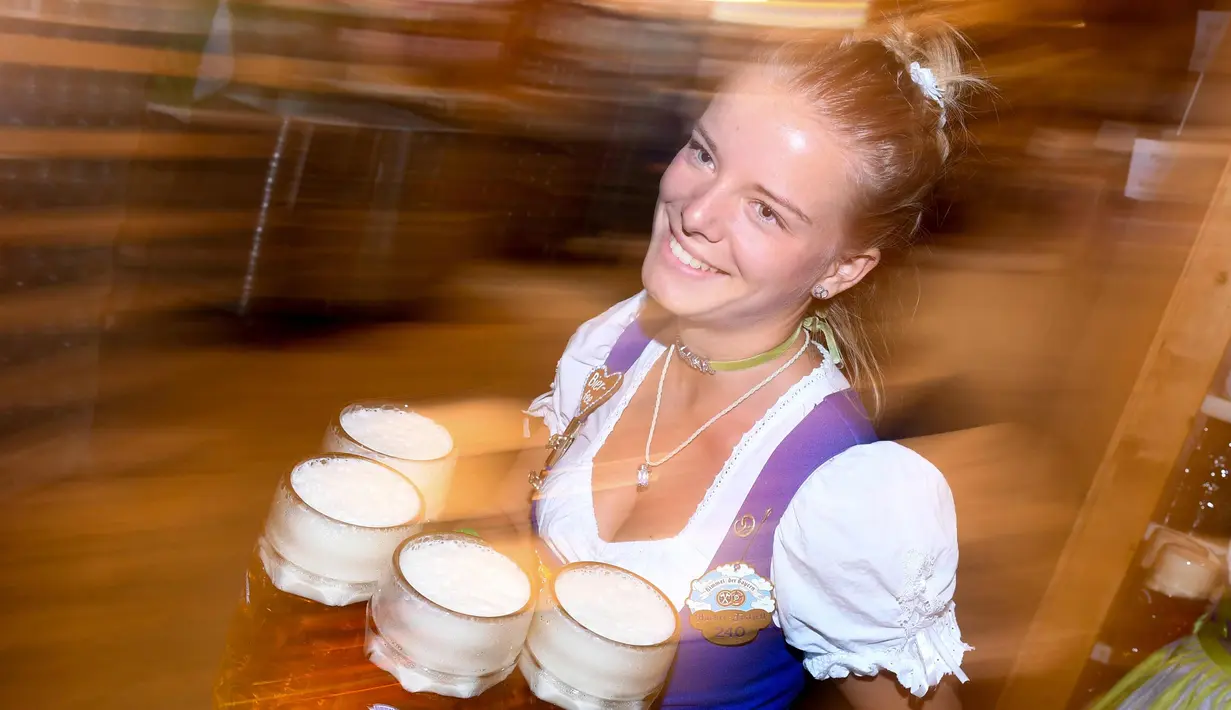 Pelayan wanita membawa gelas bir untuk pengunjung Oktoberfest di tempat peristirahatan Theresienwiese di Munich, Jerman selatan (24/9). Festival bir terbesar di dunia ini berlangsung sampai 3 Oktober 2017. (AFP Photo/dpa/Tobias Hase/Germany Out)