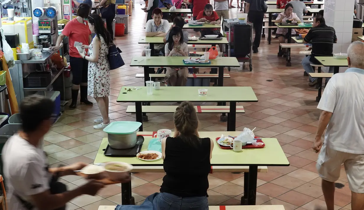 Pusat jajanan menerapkan langkah social distancing atau jaga jarak sosial dengan memasang pita perekat merah di area tempat duduk di wilayah Bugis Singapura pada 28 Maret 2020. Warga di Singapura yang melanggar perintah jaga jarak akan dikenakan denda sekitar Rp 1112 juta. (Xinhua/Then Chih Wey)