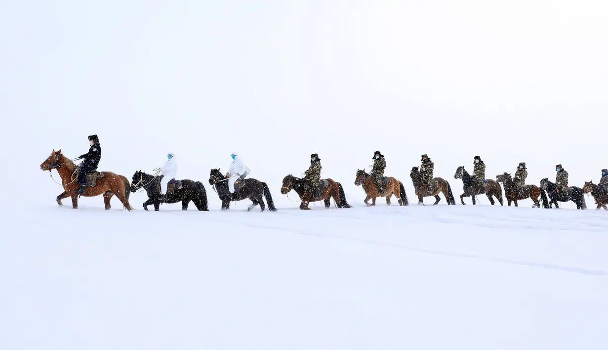 Para petugas dari unsur polisi, tentara dan tenaga medis saat melakukan perjalanan menantang saat akan mengunjungi rumah-rumah penduduk di daerah terpencil di Altay, Wilayah Xinjiang, China (19/2/2020). Mereka melakukan sosialisasi tentang bahaya virus COVID-19. (AFP/STR)