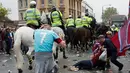 Suporter West Ham United tergeletak di jalanan saat bentrok dengan petugas kepolisian di depan Stadion Boleyn Ground, London, Selasa (10/5). Bentrokan terjadi akibat suporter West Ham United menyerangan bus skuat Manchester United. (Reuters/Eddie Keogh)