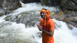 Seorang pria hindu Nepal berpose saat mandi untuk perayaan Shravan di Sundarijal di pinggiran Kathmandu (7/8). Mereka mandi sejenak dalam perjalanan menuju kuil Pashupatinath untuk mengikuti saat perayaan Shravan. (AFP Photo/Prakash Mathema)