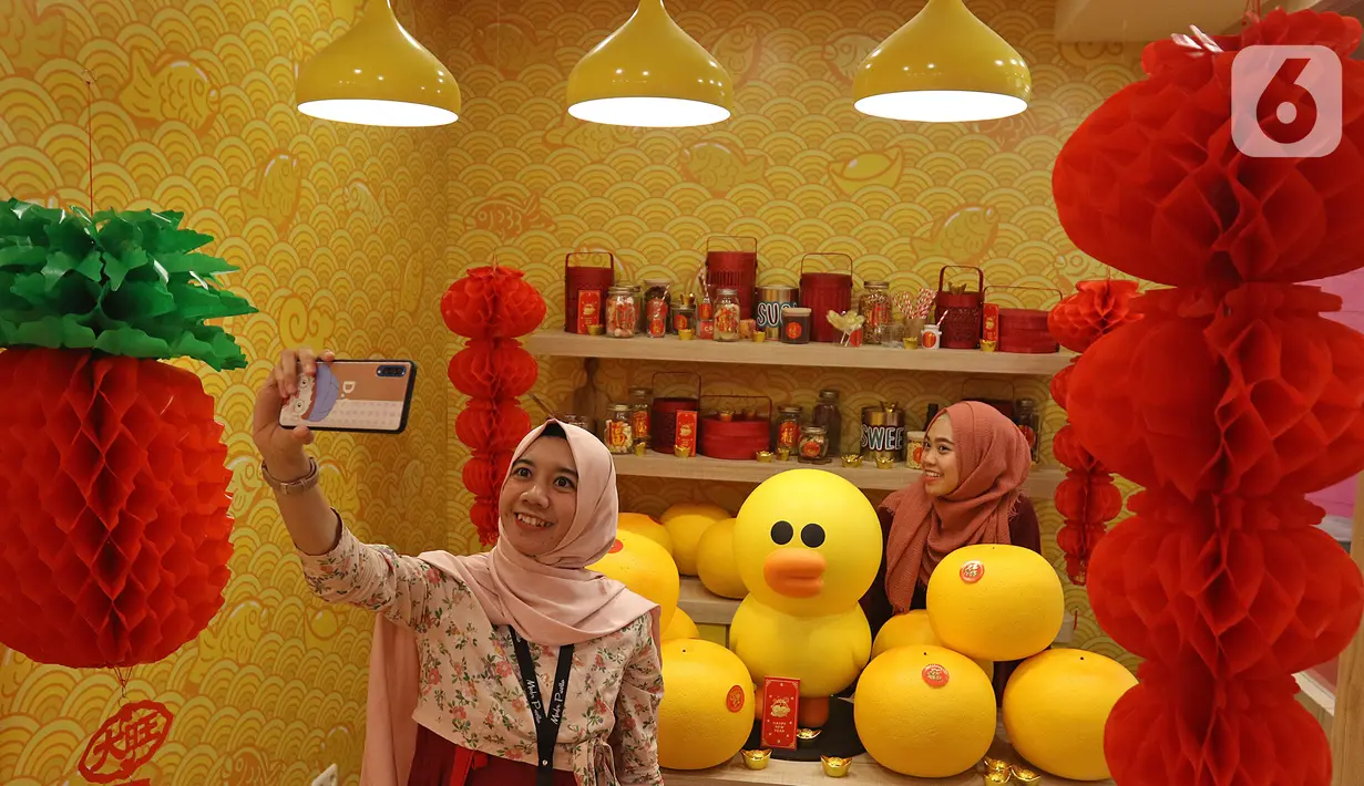Pengunjung berswafoto di instalasi BT21 di Atrium Senayan City, Jakarta, Rabu (22/1/2020). Jelang Tahun Baru Imlek, Senayan City menghadirkan instalasi Mega Brown setinggi 2,5 meter dan Pop Up Shop terbesar yang bisa dinikmati mulai 17 Januari sampai 9 Februari 2020. (Liputan6.com/Herman Zakharia)