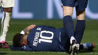 Pemain Paris Saint-Germain (PSG), Neymar, terbaring saat cedera setelah berebut bola dengan pemain Lille, Benjamin Andre, pada laga Liga Prancis di Stadion Parc des Princes, Minggu (19/2/2023). Neymar pun terpaksa ditarik keluar lapangan sembari menangis karena kesakitan. (AFP/Frank Fife)