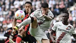 Pemain Bayer Leverkusen, Josip Stanisic, berebut bola dengan pemain Eintracht Frankfurt, Tuta pada laga Liga Jerman di Stadion Deutsche Bank Park, Senin (6/5/2024). Kemenangan ini memperpanjang rekor tidak terkalahkan mereka pada musim ini menjadi 48 laga. (AFP/Kirill Kudryavsev)