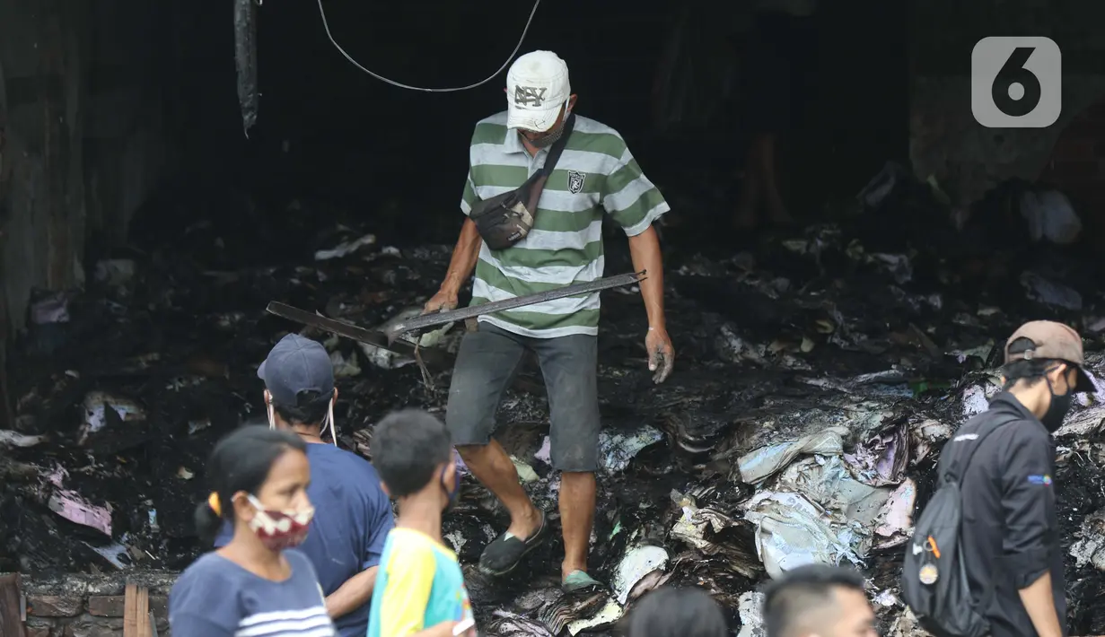 Seseorang memungut sisa barang di sebelah bioskop Grand Theater yang terbakar pada Kamis (8/10) kemarin, Jakarta, Jumat (9/10/2020). Unjuk rasa menentang Omnibus Law UU Cipta Kerja berujung aksi anarkis merusak berbagai fasilitas umum pada Kamis malam (8/10). (Liputan6.com/Helmi Fithriansyah)