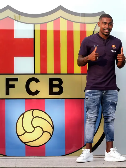Pesepakbola muda Brasil, Malcom Filipe Silva de Oliveira berpose setibanya di stadion Camp Nou,  Barcelona, Selasa (24/7). Malcom akan menjalani tes medis pada Rabu pagi sebelum bergabung dengan skuat yang menjalani tur di AS. (AP Photo/Manu Fernandez)
